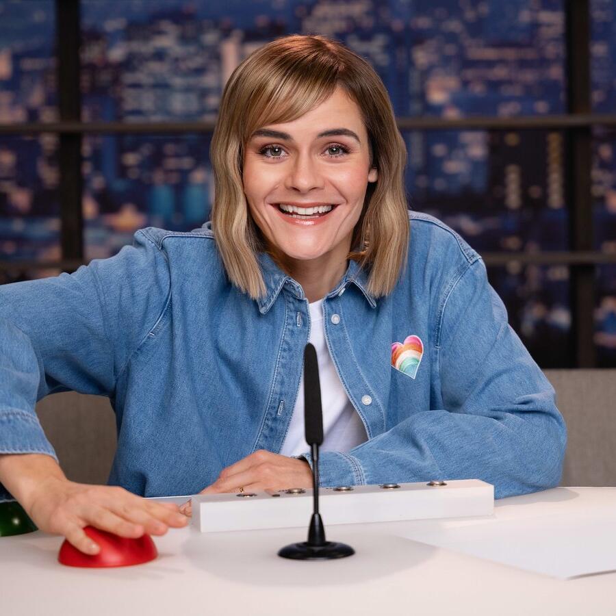 Hazel Brugger im Kontrollraum von LOL Next mit rotem Buzzer und Mikrofon