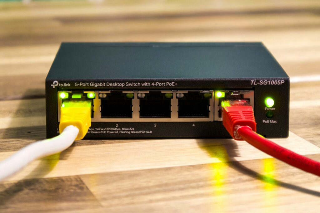 Netzwerk-Switch mit angeschlossenen Kabeln als Symbol für sichere Verbindungen
