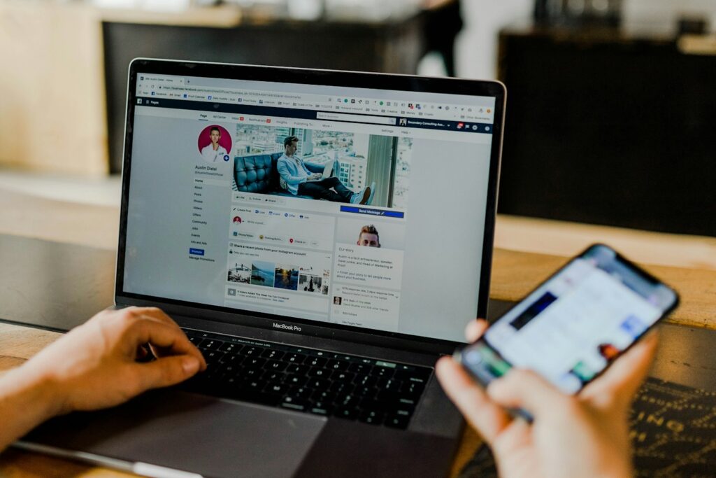 Person nutzt Laptop und Smartphone für Social Media
