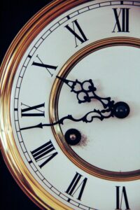 Historische braun-weiße Wanduhr mit Zifferblatt und Zeigern
