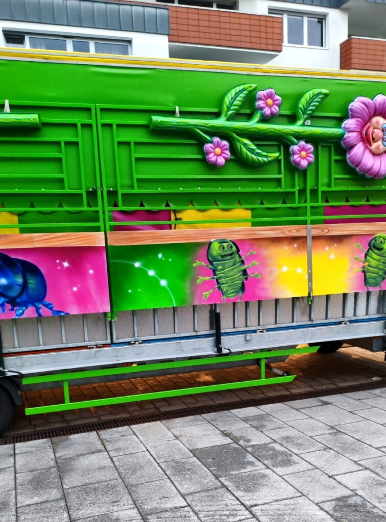 Leuchtend grüner Schaustellerwagen mit Blumenmotiven beim Aufbau des Severinsmarkts in Kamen